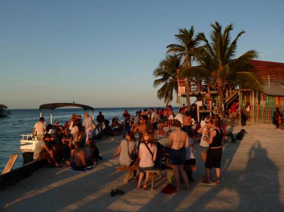 Turistas se reunem para ver o pôr-do-sol em Caye Caulker, na grande barreira de corais de Belize